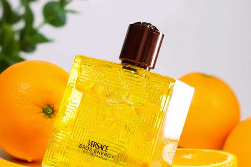 Versace Eros Energy perfume bottle with oranges in the background